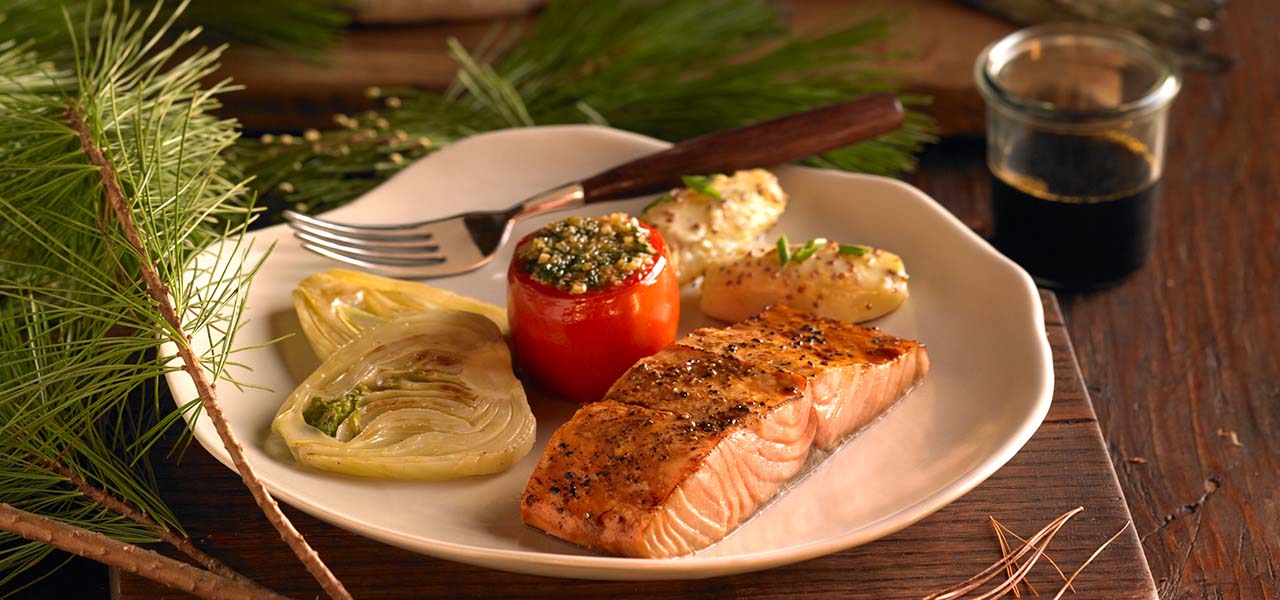 A plate of salmon and a stuffed pepper.